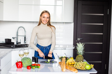 Young woman making healthy food standing happy smiling in kitchen preparing salad