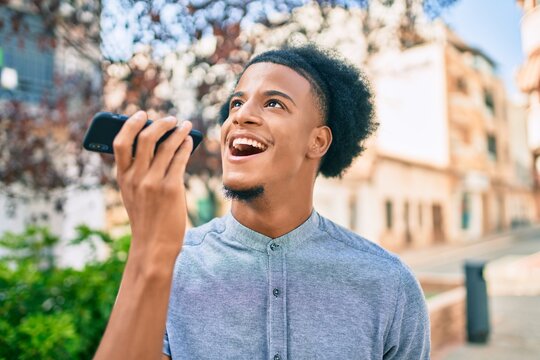 Young african american man smiling happy sending audio message using smartphone at the city.
