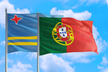 Portugal and Aruba national flag waving in the windy deep blue sky. Diplomacy and international relations concept.