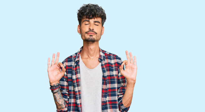 Young hispanic man wearing casual clothes relax and smiling with eyes closed doing meditation gesture with fingers. yoga concept.