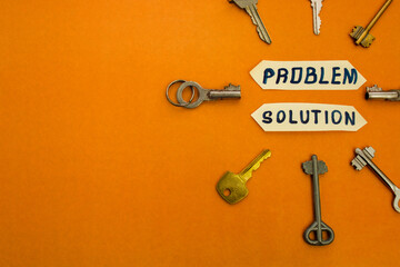 Looking for problem solution concept. Inscription "Problem solution" and many different keys around on light orange background with space for text. Top view