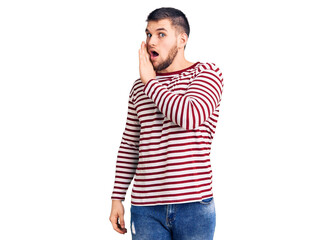 Young handsome man wearing striped sweater hand on mouth telling secret rumor, whispering malicious talk conversation