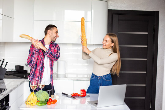 Two female and male competitors struggle for winning culinary contest, target at each other have irritated and furious expressions, use kitchen supplies as weapon for defense
