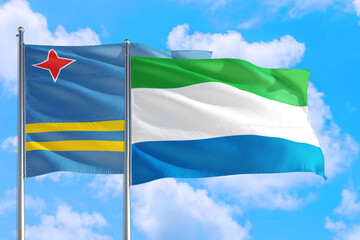 Sierra Leone and Aruba national flag waving in the windy deep blue sky. Diplomacy and international relations concept.Seychelles