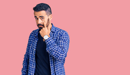 Fototapeta premium Young hispanic man wearing casual clothes pointing to the eye watching you gesture, suspicious expression