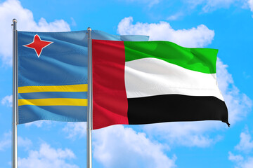 United Arab Emirates and Aruba national flag waving in the windy deep blue sky. Diplomacy and international relations concept.