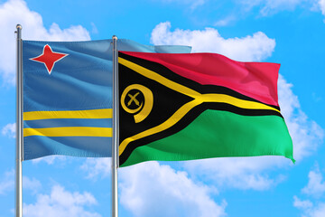 Vanuatu and Aruba national flag waving in the windy deep blue sky. Diplomacy and international relations concept.