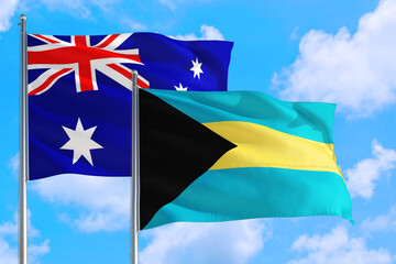 Bahamas and Australia national flag waving in the windy deep blue sky. Diplomacy and international relations concept.
