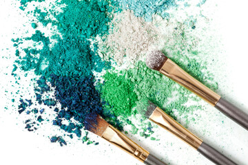 Make-up brushes and powdered cosmetic shadows isolated on a white background. 