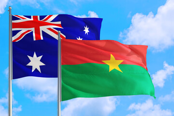 Burkina Faso and Australia national flag waving in the windy deep blue sky. Diplomacy and international relations concept.