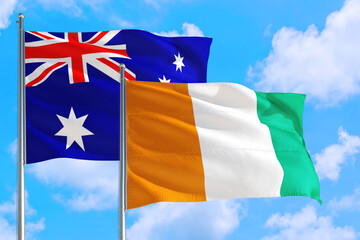 Cote D'Ivoire and Australia national flag waving in the windy deep blue sky. Diplomacy and international relations concept.