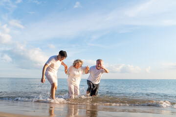 Family On Summer Beach Vacation, Father and mather running with son, Concept for .caring for the elderly, Caregiving to older persons and relations of the family to support elderly state