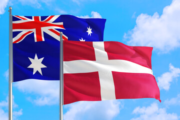 Denmark and Australia national flag waving in the windy deep blue sky. Diplomacy and international relations concept.