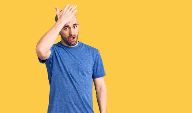 Young handsome man wearing casual t shirt surprised with hand on head for mistake, remember error. forgot, bad memory concept.