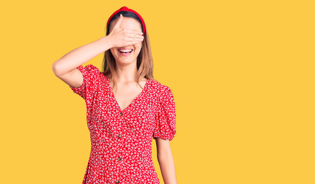 Young beautiful girl wearing dress and diadem smiling and laughing with hand on face covering eyes for surprise. blind concept.
