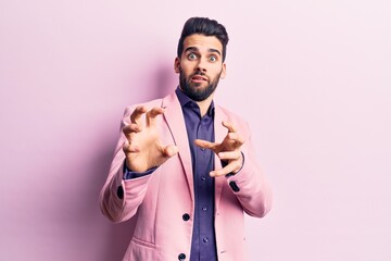 Young handsome man with beard wearing elegant jacket disgusted expression, displeased and fearful doing disgust face because aversion reaction. with hands raised