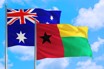 Guinea and Australia national flag waving in the windy deep blue sky. Diplomacy and international relations concept.