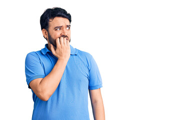 Young hispanic man wearing casual clothes looking stressed and nervous with hands on mouth biting nails. anxiety problem.