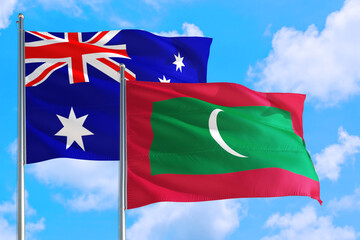 Maldives and Australia national flag waving in the windy deep blue sky. Diplomacy and international relations concept.