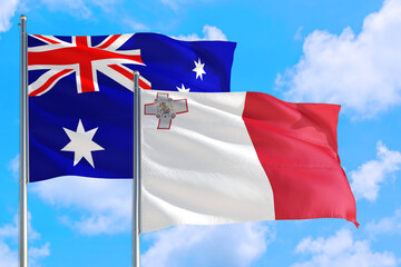Malta and Australia national flag waving in the windy deep blue sky. Diplomacy and international...