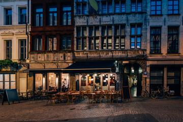 Old cozy narrow street with tables of restaurant in historic city center of Antwerpen (Antwerp),...
