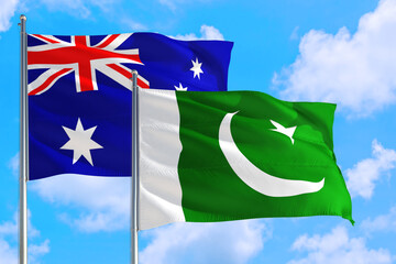 Pakistan and Australia national flag waving in the windy deep blue sky. Diplomacy and international relations concept.