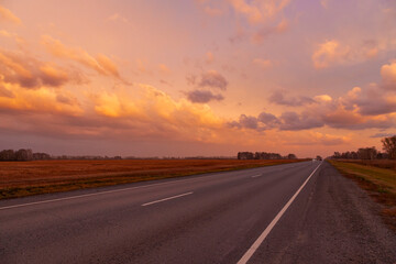 Road on the background of a picturesque sunset.