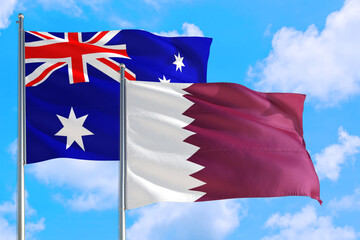 Qatar and Australia national flag waving in the windy deep blue sky. Diplomacy and international relations concept.