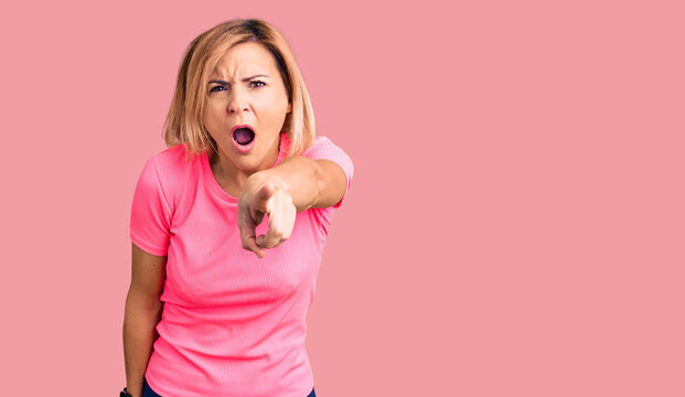 Young blonde woman wearing sportswear pointing displeased and frustrated to the camera, angry and furious with you