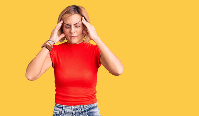 Young blonde woman wearing casual clothes with hand on head for pain in head because stress. suffering migraine.