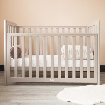 Modern baby room interior with a cozy classic crib and a soft neckroll pillow with blanket