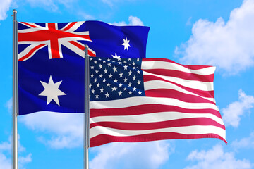 United States and Australia national flag waving in the windy deep blue sky. Diplomacy and international relations concept.