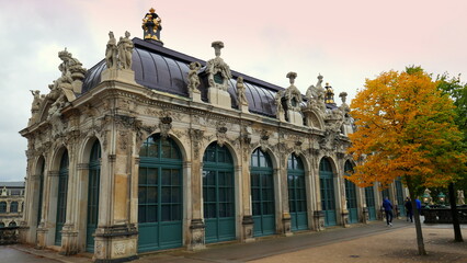 Obraz premium barocker Zwinger von Dresden mit Bäumen unter rosa Himmel gebaut von August dem Starken