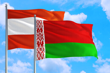 Belarus and Austria national flag waving in the windy deep blue sky. Diplomacy and international relations concept.