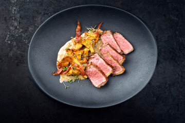 Modern style fried dry aged wagyu roast beef steak with chanterelle and bacon in cream sauce...