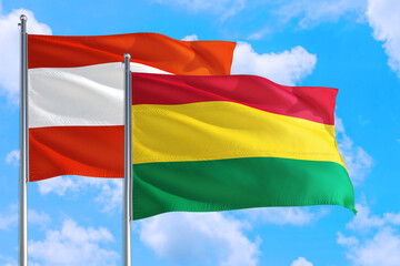 Bolivia and Austria national flag waving in the windy deep blue sky. Diplomacy and international relations concept.