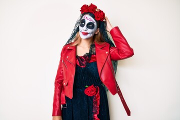 Woman wearing day of the dead costume over white confuse and wondering about question. uncertain with doubt, thinking with hand on head. pensive concept.