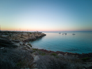 Cristal clear water and no people at the famous Cala Azzurra in Favignana, Italy. A perfect calm sunrise in this paradise island in the mediterranean sea