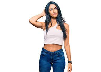 Beautiful hispanic woman wearing casual clothes confuse and wondering about question. uncertain...