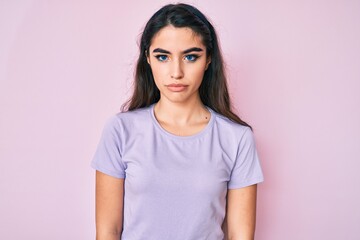 Fototapeta premium Brunette teenager girl wearing casual clothes with serious expression on face. simple and natural looking at the camera.