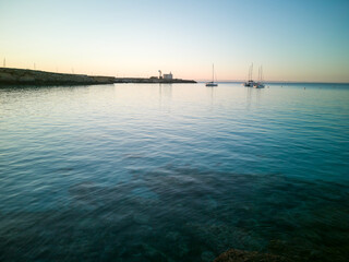 Cristal clear water and no people at the famous Cala Azzurra in Favignana, Italy. A perfect calm sunrise in this paradise island in the mediterranean sea