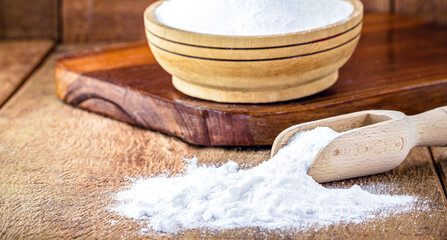 Pot of baking soda with wooden measuring spoon, chemical compound used in industry and cooking, as...