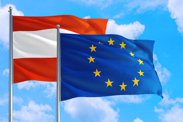 European Union and Austria national flag waving in the windy deep blue sky. Diplomacy and international relations concept.
