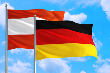 Germany and Austria national flag waving in the windy deep blue sky. Diplomacy and international relations concept.