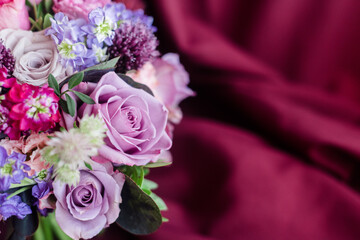 A piece of bouquet of roach roses on a purple background of fabric