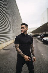 Young hot tattooed man wearing black classic clothes