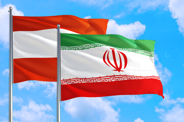 Iran and Austria national flag waving in the windy deep blue sky. Diplomacy and international relations concept.