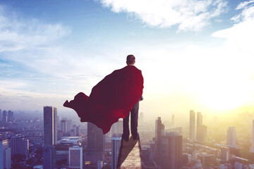 Businessman wearing a red cape in office rooftop