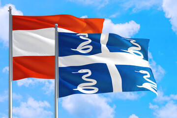 Fototapeta premium Martinique and Austria national flag waving in the windy deep blue sky. Diplomacy and international relations concept.