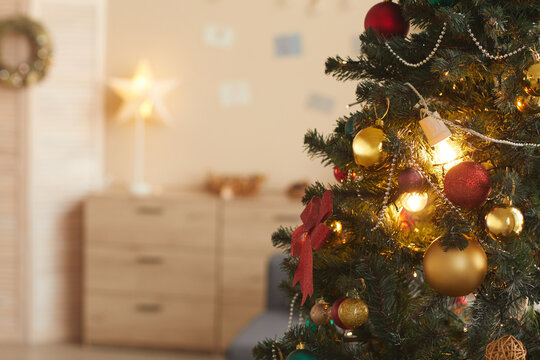 Background image of beautiful Christmas tree decorated with golden baulbs in cozy home interior, copy space